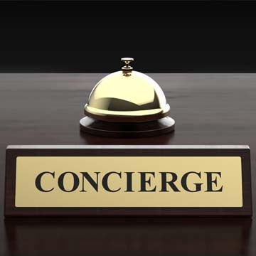 Concierge desk bell and sign on table.