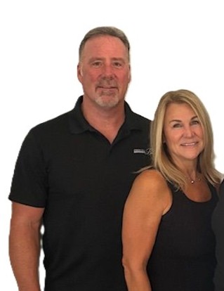 Man and woman posing in black outfits.